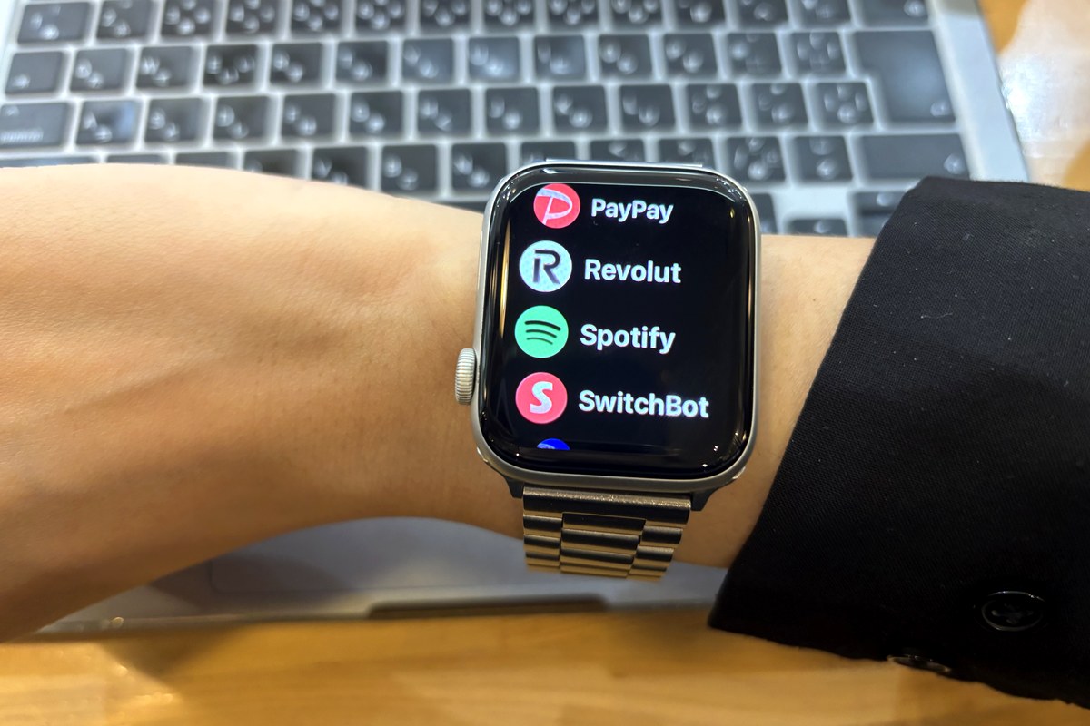 腕に着けたApple Watch。PayPay・Revolut・Spotify・SwitchBotのアプリが並ぶ画面