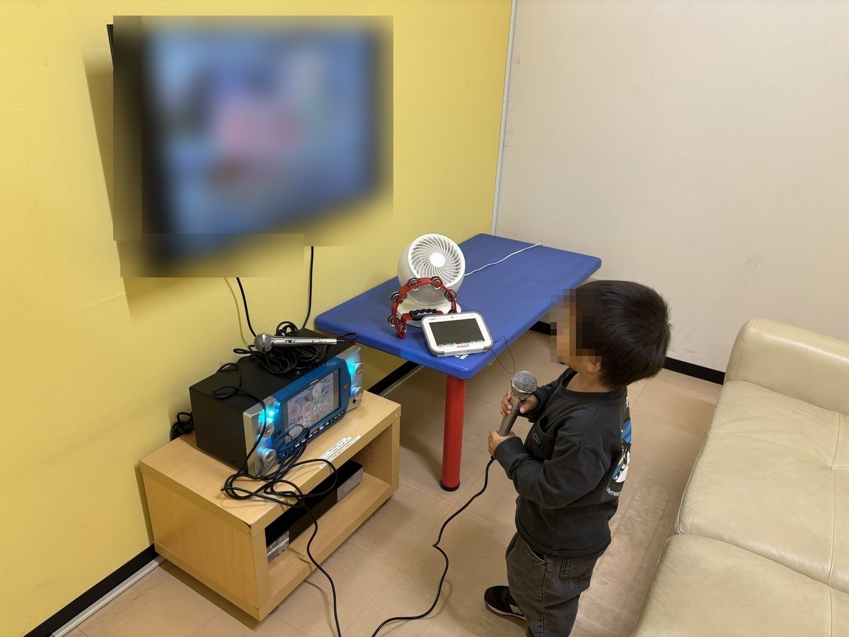 キッズランドUS神戸甲南山手店のカラオケコーナー。テレビとマイク、ソファのある小部屋
