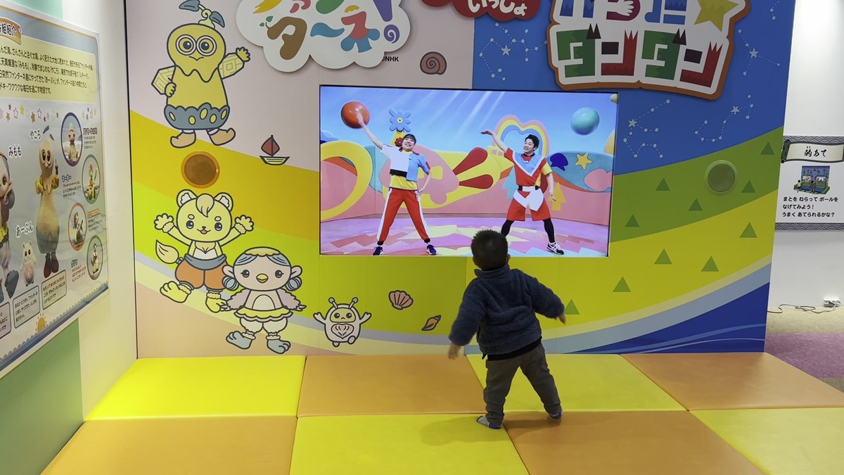 東条湖おもちゃ王国のこどもスタジオ（2024年開催時）で、ファンターネ！とからだ☆ダンダンの映像に合わせて踊る2歳の子どもの後ろ姿
