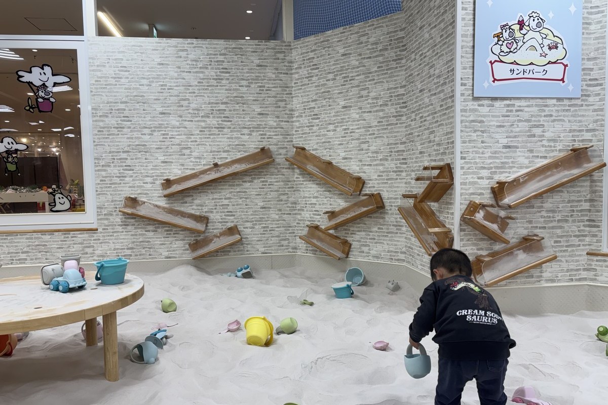 ピュアハートキッズランドコロワ甲子園のサンドパーク。白い砂場で砂遊びをする子ども
