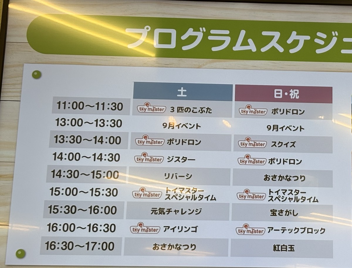 プログラムスケジュールの掲示。土曜と日曜・祝日の11時から17時まで、30分ごとのプログラム名が並んでいる