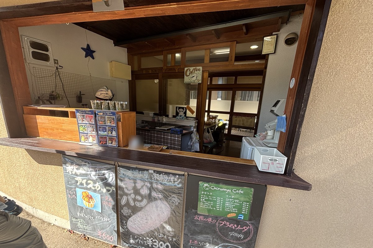 受付横のちるみゅーカフェの窓口。黒板に秋のアイスカップ600円、きなこパン300円、プラムソーダ400円、紅茶シェイク400円のメニュー