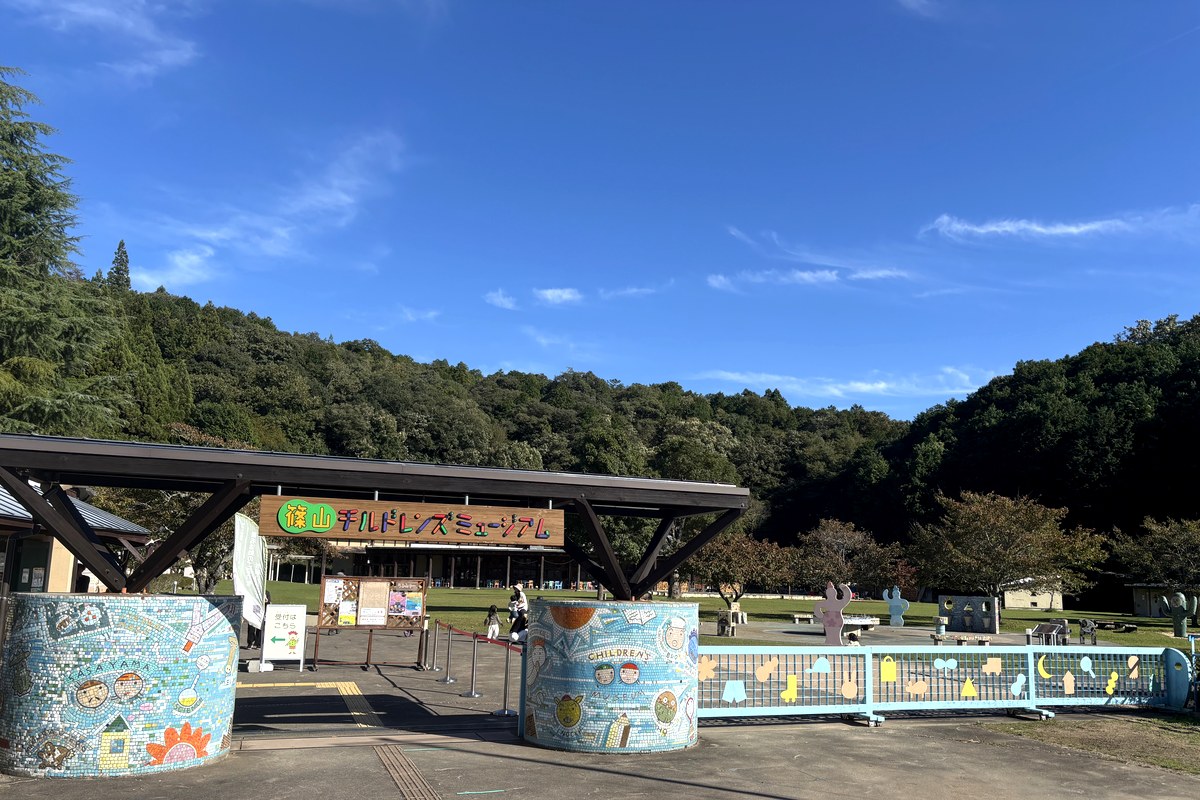 モザイクタイルで飾られた入口の門。奥に校庭と校舎が見える