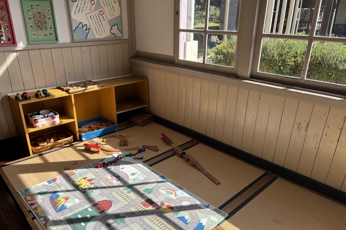昔あそびのコーナーの全景。畳の部屋に木のおもちゃの棚とけん玉・コマ